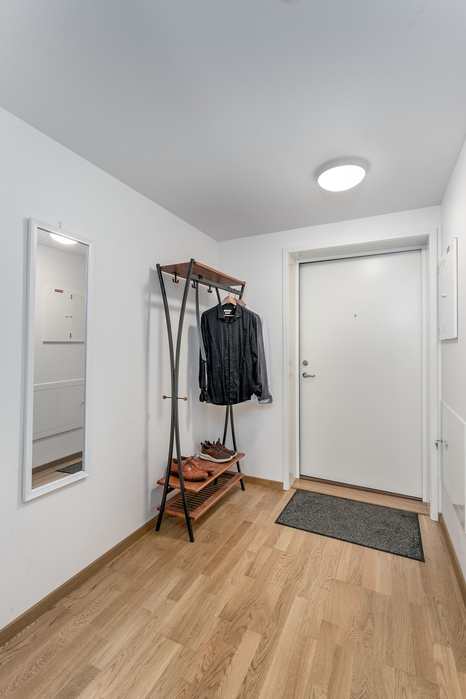 Innbydende entre/gang med malte slette veggflater og trestavs eikeparkett på gulv, som gir et godt førsteinntrykk av leiligheten. Det er montert dørcalling ved inngangsdøren.